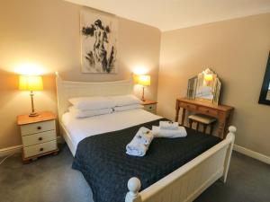 a bedroom with a bed with two towels on it at Brewers Cottage in Pickering