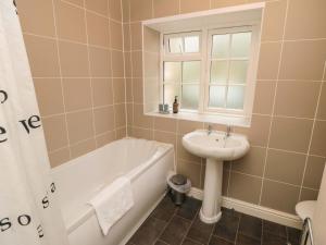 a bathroom with a sink and a bath tub and a sink at Brewers Cottage in Pickering