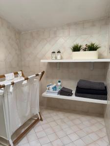 a bathroom with white shelves with towels and plants at A casa di zia Maly in Palena