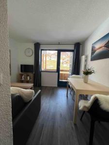 a living room with a couch and a dining room table at Appartement centre de Val Thorens ski in skinout in Val Thorens
