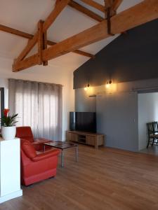 a living room with a red couch and a tv at Julie in Saint-Bonnet-sur-Gironde
