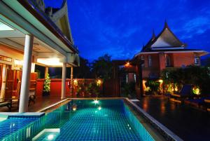 a swimming pool in front of a house at night at Chaweng Resort in Chaweng