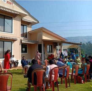 a group of people sitting in chairs in front of a house at Patankar Nest Homestay in Helwāk +4 photos