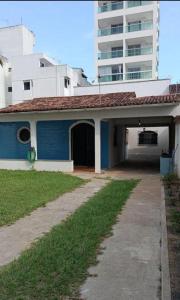 a blue and white house with a building at Casa praia Guarapari in Guarapari