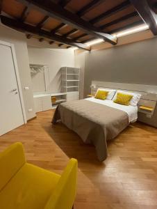Un dormitorio con una cama grande y una silla amarilla. en Casa Palanca, en Stia