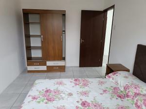 a bedroom with a bed and a dresser and a closet at Bela casa de praia in Palhoça