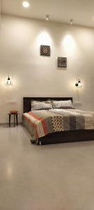 a bedroom with a bed and a table and lights at Chilkur Balaji Lakeview Villa in Gundipet
