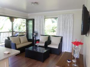 a living room with two couches and a table at Hillside Retreat in Baie Lazare Mahé