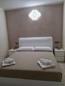 a bedroom with a bed with two towels on it at B&B La Ninfa del Lago in Lesina