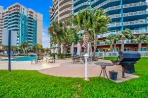 a park with tables and a grill and palm trees at Legacy Tower I 903 in Gulfport