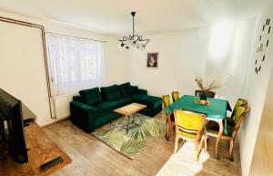 Una sala de estar con un sofá verde y una mesa. en Divčibarski M.S.A. kutak, en Divčibare