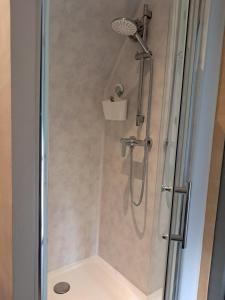 a shower with a glass door in a bathroom at Le grenier de Mamou in Hesdigneul-lès-Boulogne