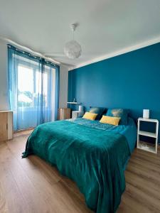 ein blaues Schlafzimmer mit einem großen Bett und einer blauen Wand in der Unterkunft Villa Quintel -Proche gare & centre -JardinBalcon in Brive-la-Gaillarde