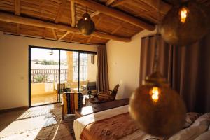 a hotel room with a bed and a balcony at Sahara pearl Hotel in Merzouga