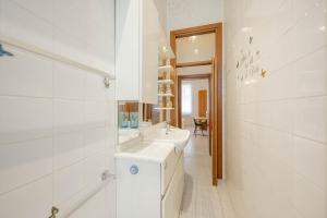 a white bathroom with two sinks and a mirror at Venice Marine - 10 minuti da Venezia in Mestre