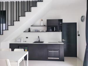 a kitchen with black cabinets and a staircase at Villa Coco - Tropical Paradise with Private Pool in Thalang +26 photos