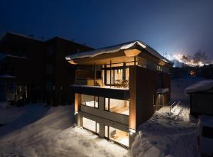 a building in the snow at night at Kazahana 風華 in Kutchan