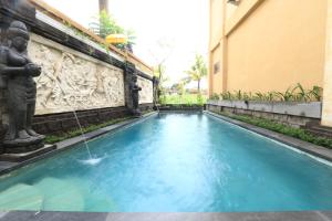 una piscina con fontana in un edificio di Frangipani Bungalow ad Ubud