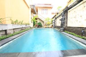 una piscina in una casa con acqua blu di Frangipani Bungalow ad Ubud