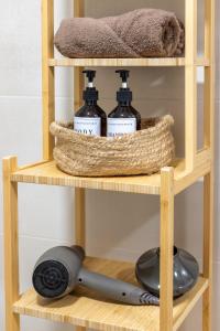 una estantería de madera con tres botellas de detergente en Jome Stays Alicante centro, en Alicante