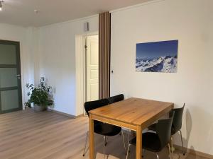 a dining room with a wooden table and chairs at Modern apartment Kvaløya in Kvaloysletta +10 photos