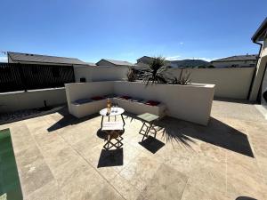 a patio with a table and a couch on a balcony at Villa exotique avec piscine - Dolce Rhôna in Charmes-sur-Rhône