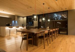 a dining room with a large wooden table and chairs at Kazahana in Niseko