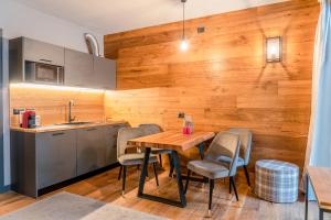 a kitchen with a wooden wall and a wooden table and chairs at Chalet K2 in Prato Nevoso