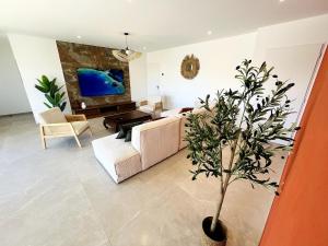 a living room with a couch and a potted tree at Villa exotique avec piscine - Dolce Rhôna in Charmes-sur-Rhône