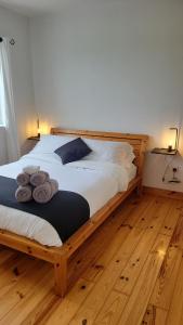 um quarto com uma cama de madeira e toalhas em Coastal View Cottage em Mullagh