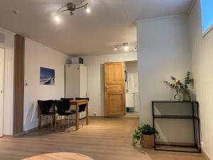 un salon avec une table, des chaises et un réfrigérateur dans l'établissement Modern apartment Kvaløya, à Kvaloysletta 9 autres photos