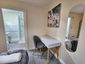 a room with a desk and a chair and a mirror at Two Bedroom Apartment by Brookland Stays Serviced Accommodation Short Lets Coventry with Free WiFi in Wyken +4 photos