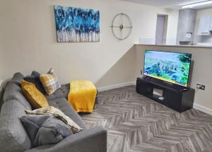 a living room with a couch and a flat screen tv at Two Bedroom Apartment by Brookland Stays Serviced Accommodation Short Lets Coventry with Free WiFi in Wyken