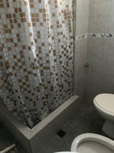 サンベルナルドにあるSan Bernardo, hermoso dpto. a 2 cuadras del mar y 1 del centro para 6 personasのトイレとシャワーカーテン付きのバスルーム