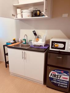 a small kitchen with a sink and a microwave at Minimalist Condo Avida Tower 4 in Iloilo City