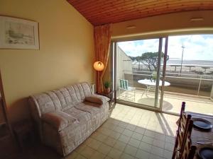 a living room with a couch and a large window at Saint Georges de Didonne - APPARTEMENT FACE à la PLAGE - Etoile de Mer in Saint-Georges-de-Didonne