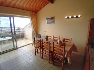 a dining room with a table and a balcony at Saint Georges de Didonne - APPARTEMENT FACE à la PLAGE - Etoile de Mer in Saint-Georges-de-Didonne