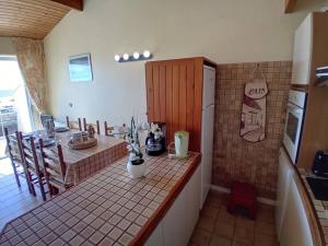 a kitchen with a counter and a table and a refrigerator at Saint Georges de Didonne - APPARTEMENT FACE à la PLAGE - Etoile de Mer in Saint-Georges-de-Didonne