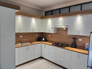 a kitchen with white cabinets and a sink at Executive Apartment in Ramos Arizpe
