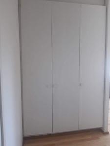 a row of white closets in a room at Peaceful studio in Vantaa in Vantaa