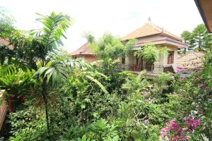 una casa rodeada de árboles y plantas en Frangipani Bungalow, en Ubud