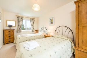 a bedroom with two beds and a dresser at Cothi Cottage in Cardigan