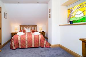 une chambre avec un lit et un tableau au mur dans l'établissement Teifi Cottage, à Cardigan