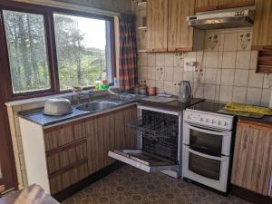 a kitchen with a stove and a sink and a window at Dry Harbour in Enniskillen