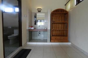 a bathroom with a toilet and a sink and a mirror at Frangipani Bungalow in Ubud +75 photos