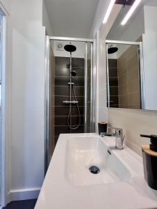 biała łazienka z umywalką i prysznicem w obiekcie Casa #1407 - T2 Climatisé avec Balcon - Hyper Centre w mieście Brive-la-Gaillarde