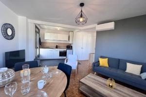 salon z niebieską kanapą i stołem w obiekcie Casa #1407 - T2 Climatisé avec Balcon - Hyper Centre w mieście Brive-la-Gaillarde