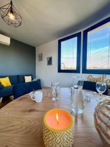 świeca na drewnianym stole w salonie w obiekcie Casa #1407 - T2 Climatisé avec Balcon - Hyper Centre w mieście Brive-la-Gaillarde +13 zdjęć