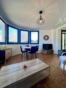 duży salon ze stołem i krzesłami w obiekcie Casa #1407 - T2 Climatisé avec Balcon - Hyper Centre w mieście Brive-la-Gaillarde