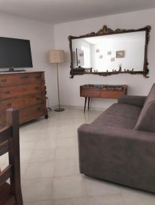 a living room with a couch and a dresser and a mirror at La casa Sul Lago in Colledimezzo